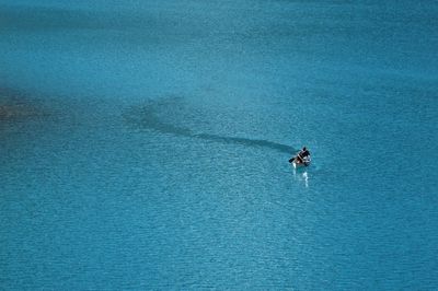 Man sailing on rowboat in sea