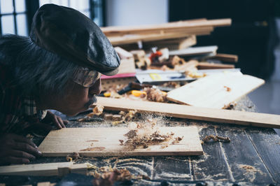 Man blowing saw dust