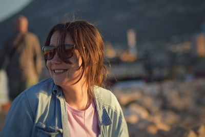 Close-up of woman wearing sunglasses during sunset