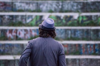 Rear view of man standing against graffiti steps