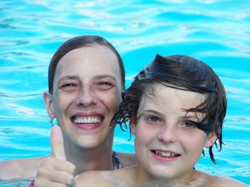 Portrait of smiling young woman swimming in pool