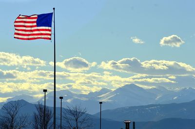 Low angle view of mountain range against cloudy sky