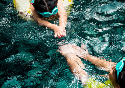 Low section of people swimming in pool