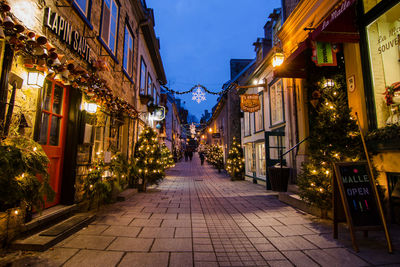 Illuminated street amidst city at night