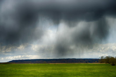 Scenic view of field against cloudy sky