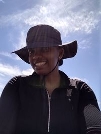 Portrait of smiling man wearing hat against sky