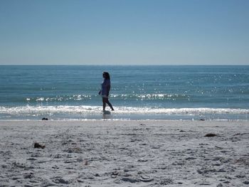 Full length of man on beach against clear sky