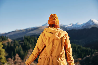 Rear view of woman standing against mountain