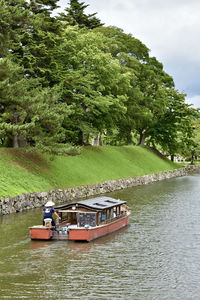 Boats in  the outer  moat of the hikone castle against trees