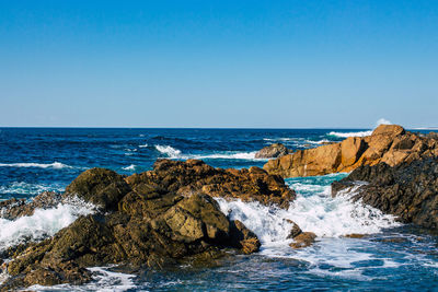 Scenic view of sea against clear blue sky