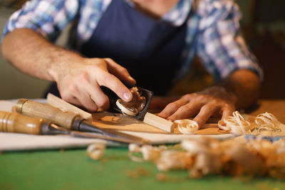 Midsection of carpenter working in workshop