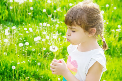 Portrait of girl blowing bubbles on field