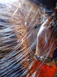 Close-up of woman with feather against blurred background