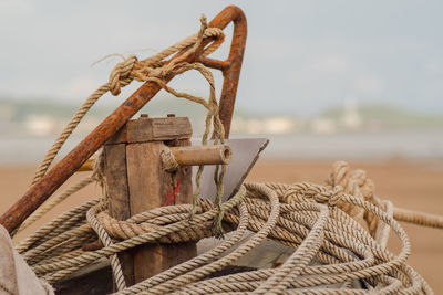 Close-up of rope tied on wood against sea