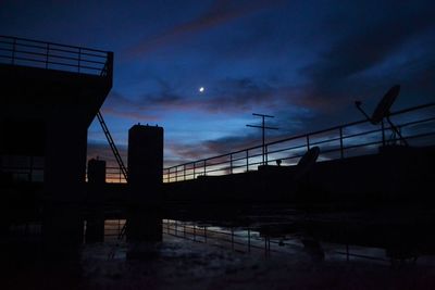 Silhouette railing against sky at sunset