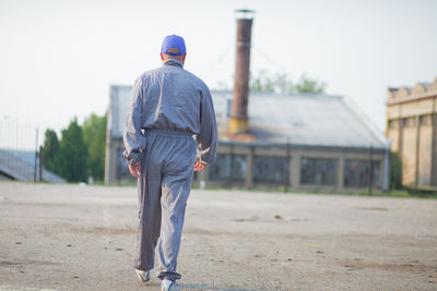 Rear view of man walking on building