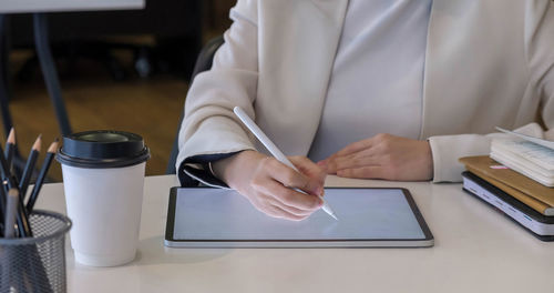 Midsection of man using laptop on table