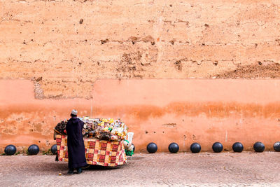 Rear view of people standing against wall