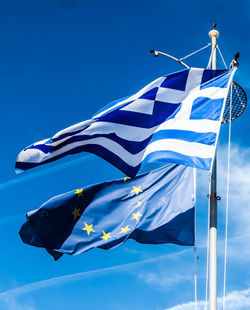 Low angle view of flag against blue sky