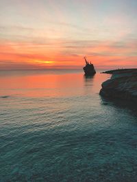 Silhouette boat in sea against sky during sunset