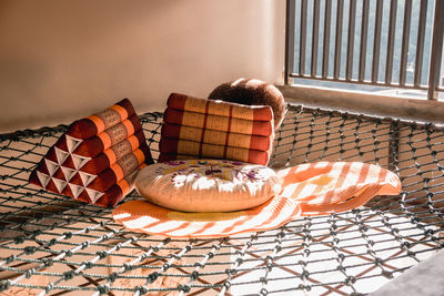 Seating net with pillow and rug hanging on second floor. net for seat and bed with sun light.