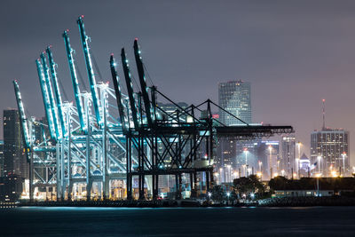 Illuminated modern buildings against sky at night