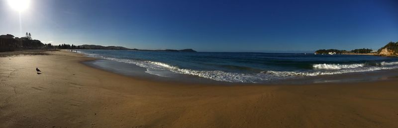 Scenic view of beach against clear blue sky