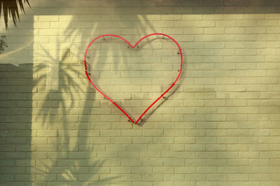 Close-up of heart shape on brick wall
