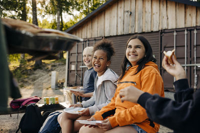 Happy kids enjoying while having food at summer camp