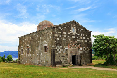 Old building on field against sky