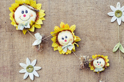 Close-up of artificial sunflowers hanging on textile