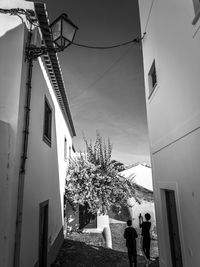 People walking on street amidst buildings against sky