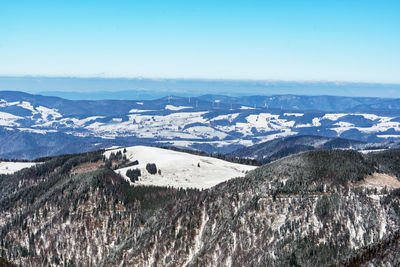 Aerial view of snowcapped mountains against clear sky