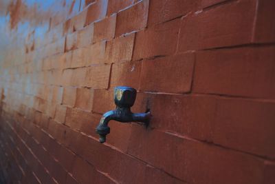 Close-up of faucet on brick wall