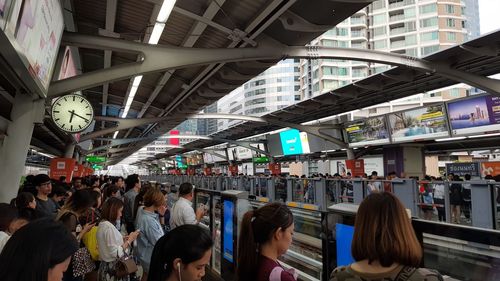 Rear view of people waiting on railroad station