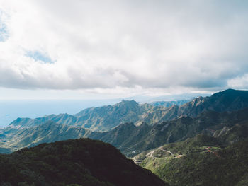 Scenic view of mountains against cloudy sky