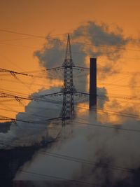 Electricity pylon against cloudy sky