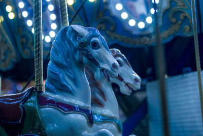 Low angle view of carousel horses at night