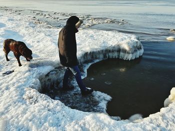 Man with dog on beach during winter