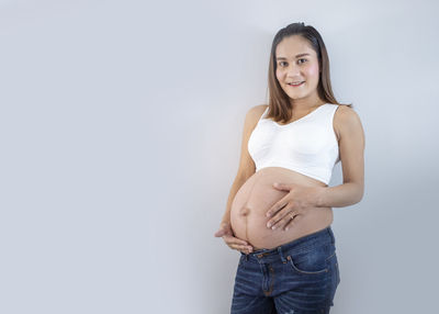 Portrait of a smiling young woman against white background