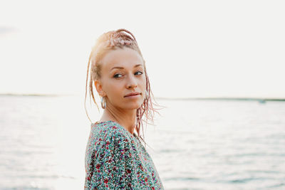 Close-up of young woman looking away by lake