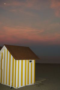 Scenic view of beach hut at sunset