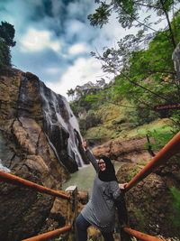 Rear view of woman with arms outstretched against mountain range