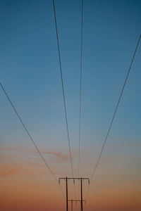 Low angle view of cables against clear sky at sunset