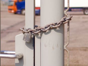 Close-up of chain tied to metal pole