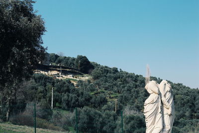 Statue by trees against clear sky