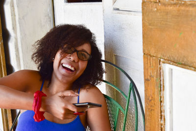 Portrait of smiling young woman using mobile phone