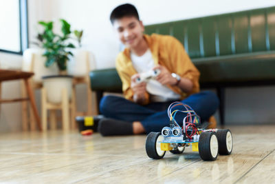 Full length of boy playing with remote control car at home