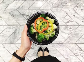 Low section of woman holding salad in bowl