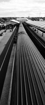 Railroad tracks by sea against sky